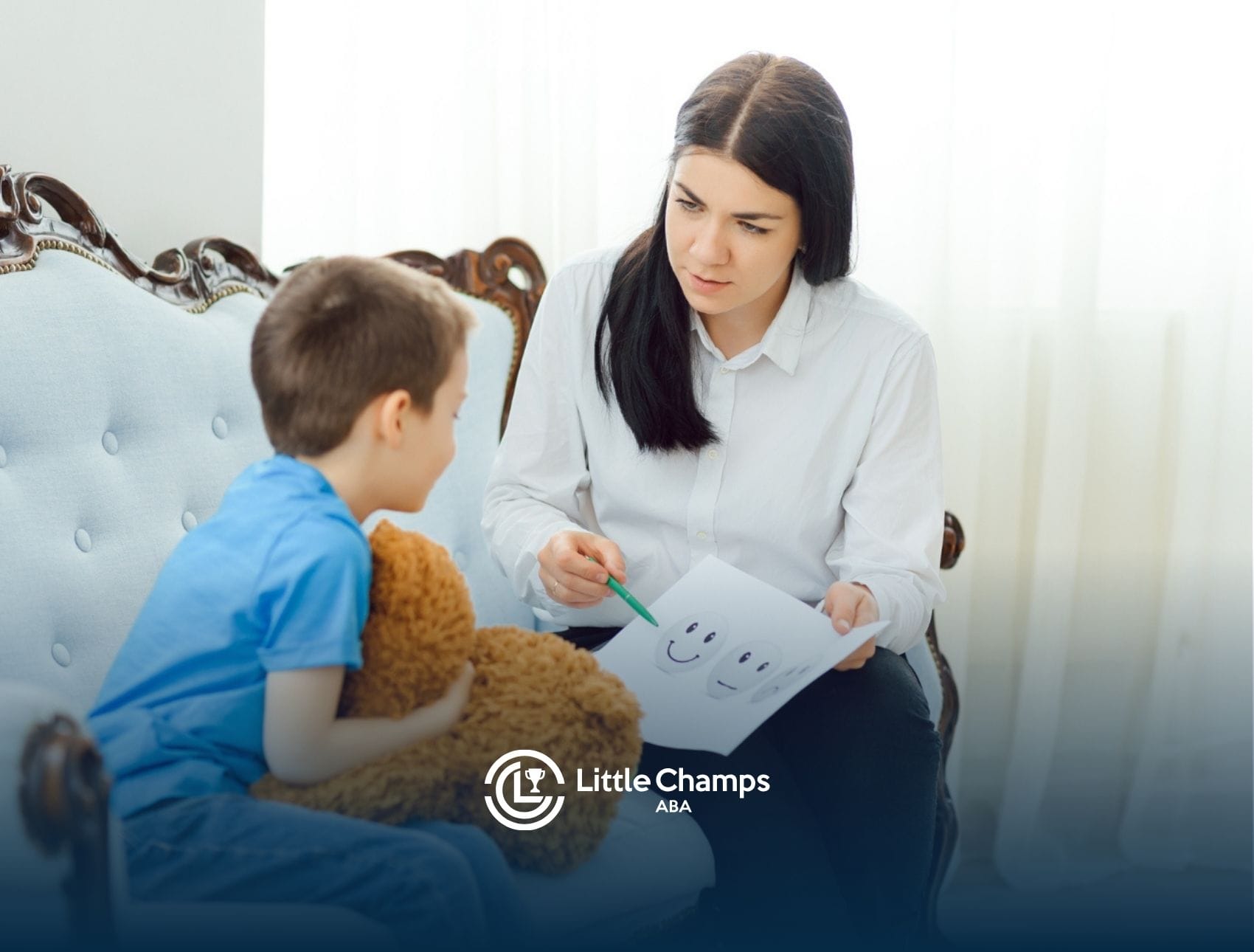 Autistic boy looking at a paper with faces drawn on it during a therapy session.