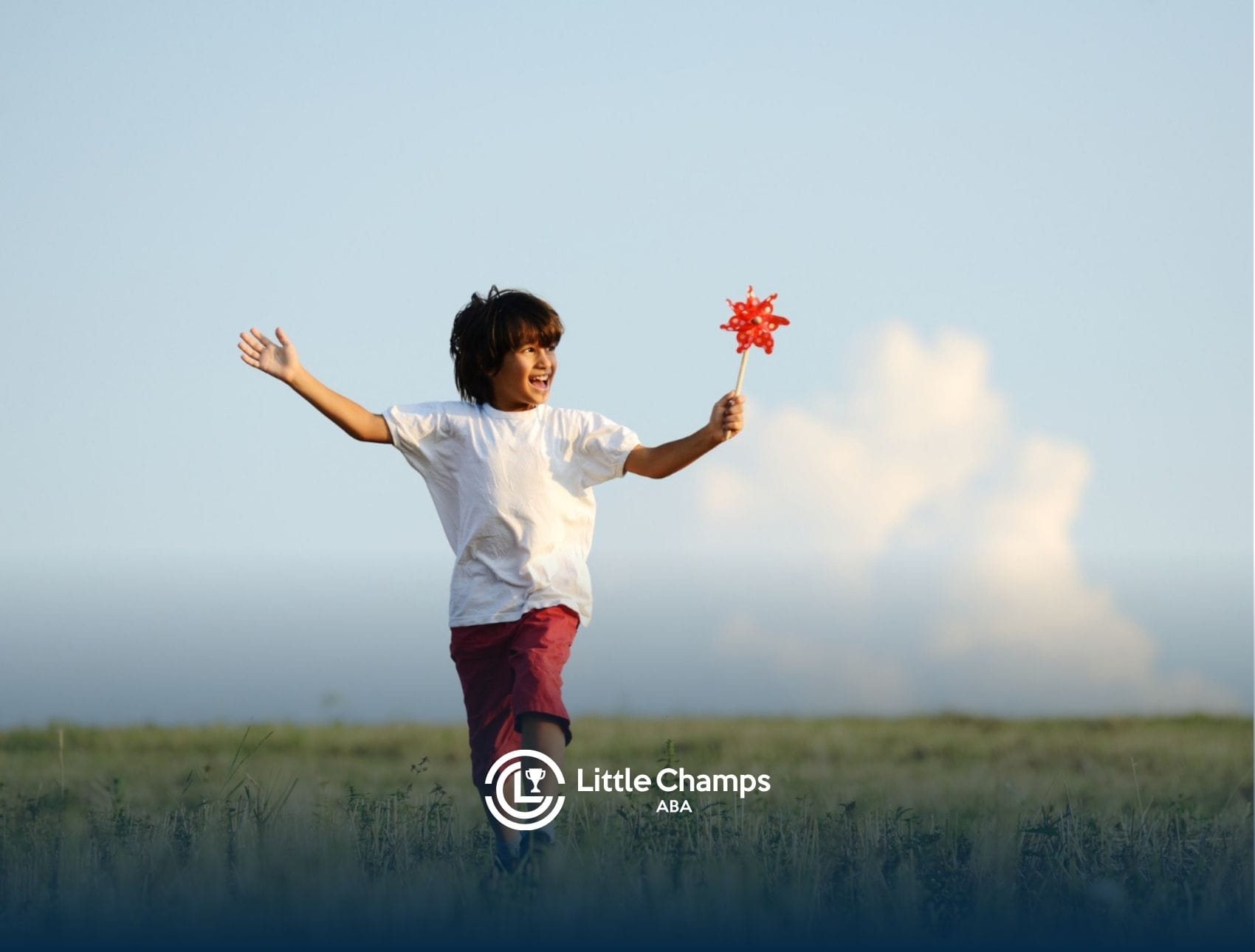 Autistic child running through a field holding a red pinwheel.