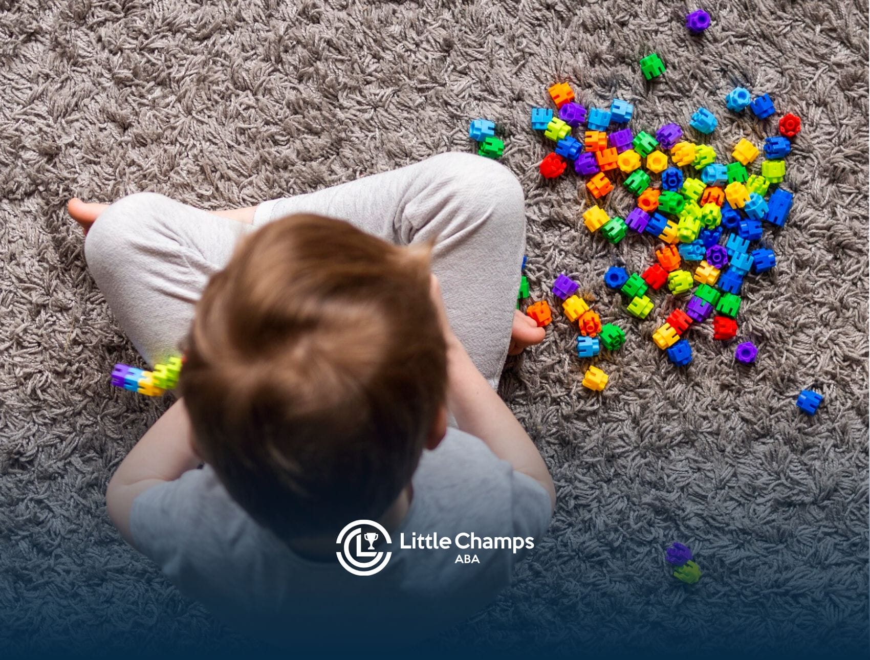 A child with autism is playing with colorful toys on the floor