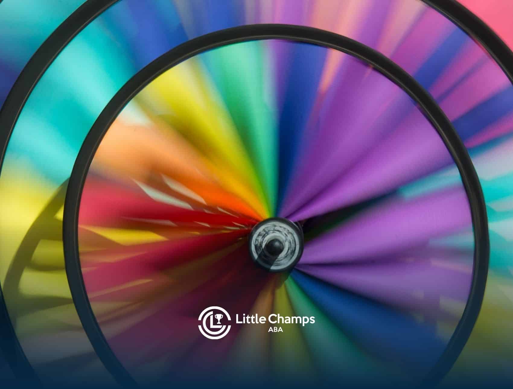 A spinning rainbow-colored pinwheel with blurred motion effect, symbolizing autistic spectrum wheel.