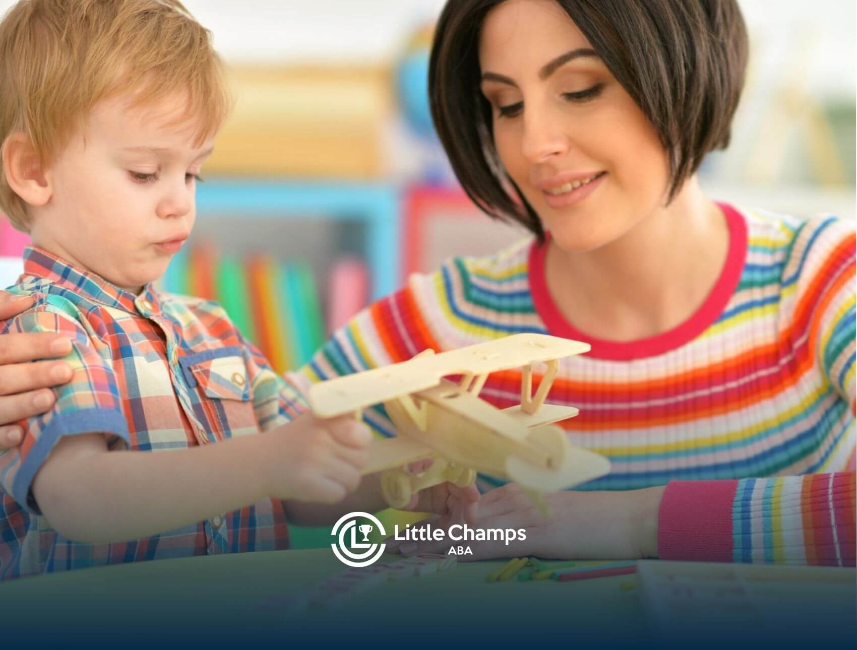 ABA therapist and boy playing with a wooden airplane in ABA therapy.