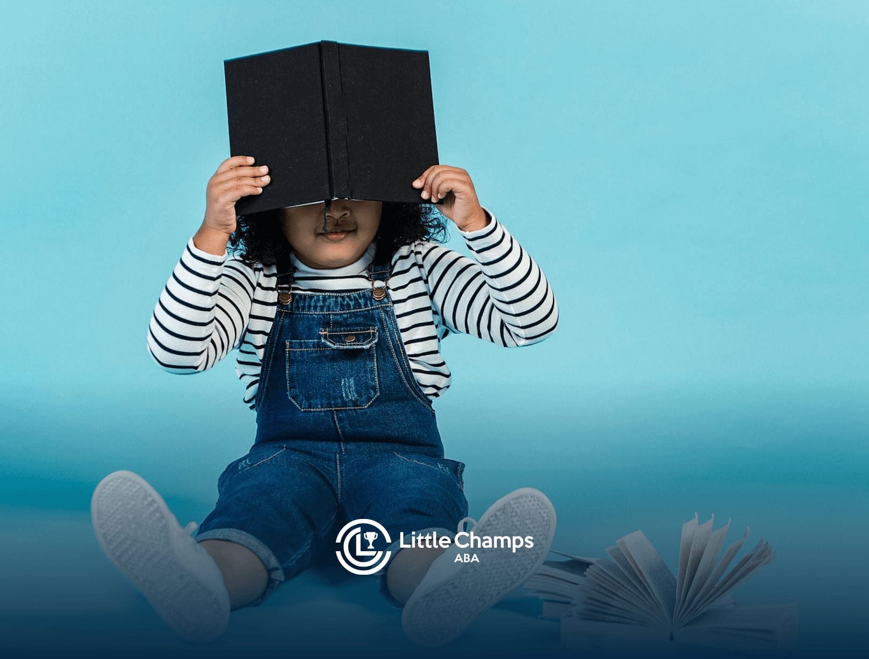 An autistic child avoiding eye contact with a book during school-based ABA therapy conversation in Utah.