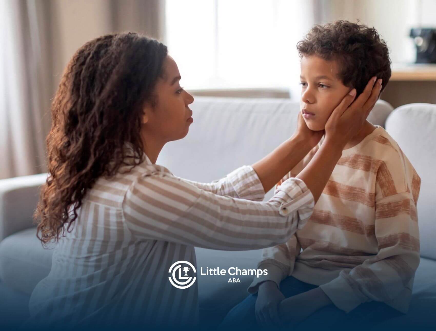 An ABA therapist comforting a boy with autism while sitting on couch in ABA therapy.