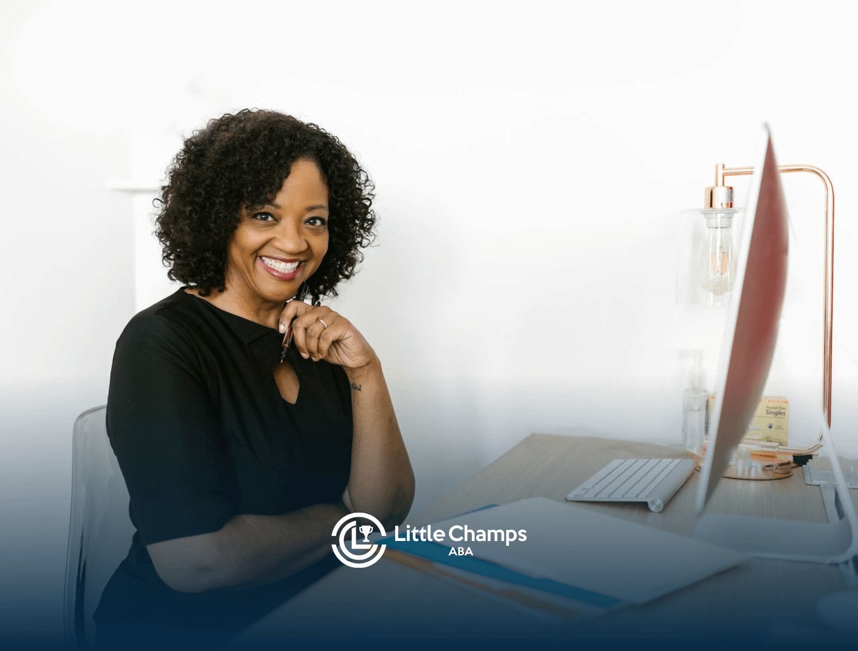 Smiling BCBA professional who successfully passed BCBA exam is working at desk with computer in Colorado.