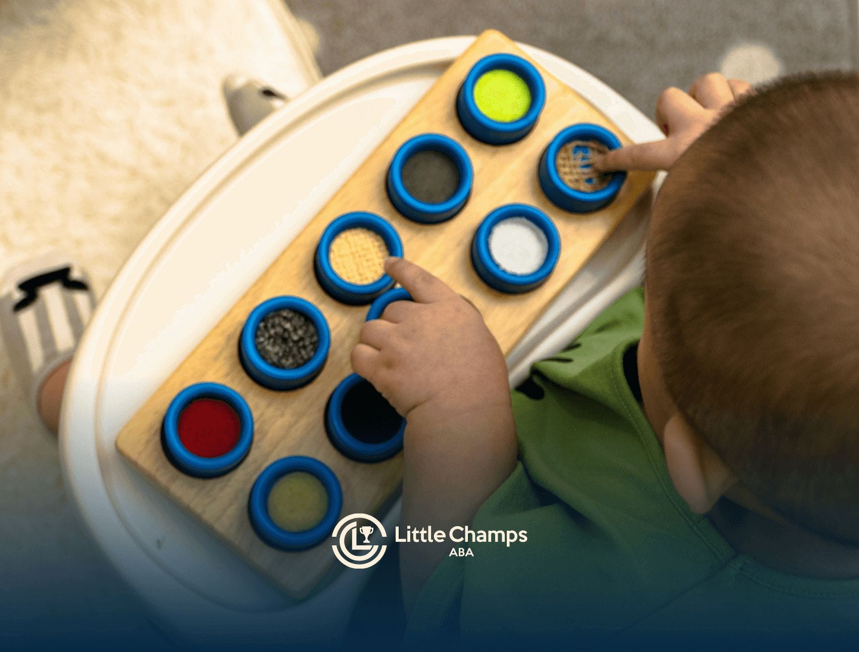 An autistic child playing with sensory texture board during center-based ABA therapy session in Utah.