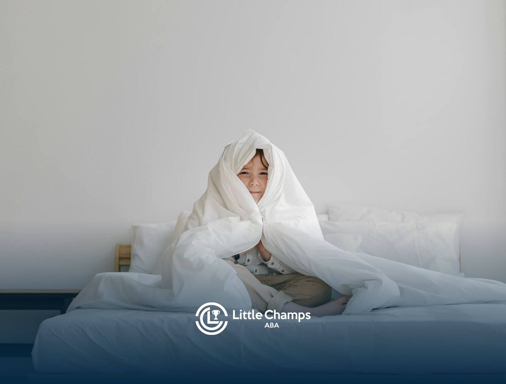 Autistic child sitting on a bed wrapped in a white blanket in a bright minimal room after therapy.